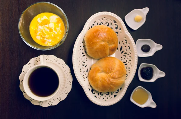 Tasse de thé, carafe à eau chaude et joli bol blanc avec deux beaux pains à l'intérieur, sélection de marmelade — Photo