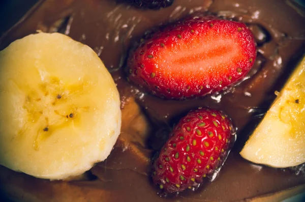 Closeup pancake covered with chocolate, decorated using bananas and strawberries as seen from above — Stock Photo, Image