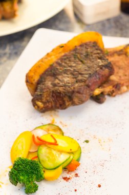 Mükemmel pişmiş biftek chorizo hâlâ bağlı kalın yağ ile kesmek için beyaz tabak, zarif sunum yerleştirilen