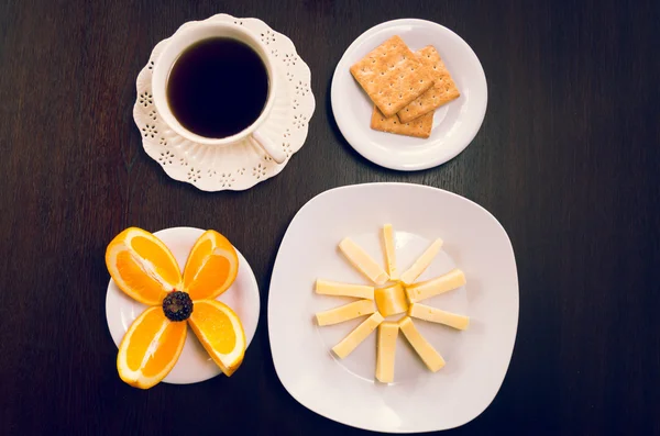 Concept de petit déjeuner élégant vu d'en haut, tasse à café, oranges tranchées, craquelins et fromage — Photo