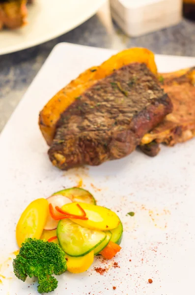 Chorizo de steak parfaitement cuit avec de la graisse épaisse encore attachée à la coupe, placée sur une assiette blanche, présentation élégante — Photo