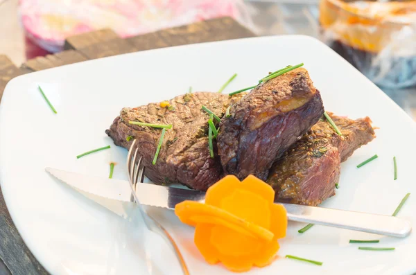 Delicious rump steak cooked to perfection and placed upon white dinner plate, elegant presentation