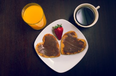 Heartshaped krep çikolata ve çilek, portakal suyu, kahve Kupası ile kaplı zarif kahvaltı kavramı yukarıdan, görüldüğü gibi