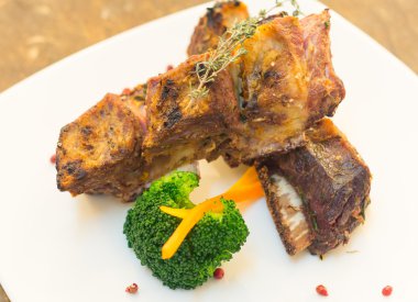 Lezzetli kaburga et ve sebze yerleştirilmiş beyaz tabağında, zarif sunum