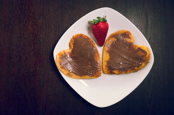 Crêpes en forme de cœur recouvertes de chocolat et de fraise vu d'en haut, concept de petit déjeuner élégant — Photo