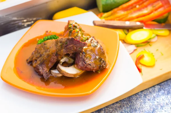 Delicious medium rare sirloin steaks and vegetables placed on orange plate, elegant presentation