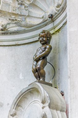 Brussels, Belçika - 11 Ağustos, 2015: Manneken Pis ünlü dönüm noktası bronz heykeli küçük çocuk çeşmeye peeing