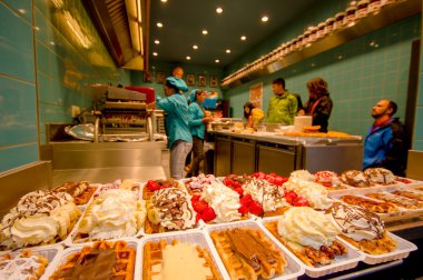 Brussels, Belçika - 11 Ağustos, 2015: Belçika waffle mağaza içinde birçok lezzetli tabaklar dizilmiş çikolata, krema, çilek ve karamel gibi farklı Topingler ile