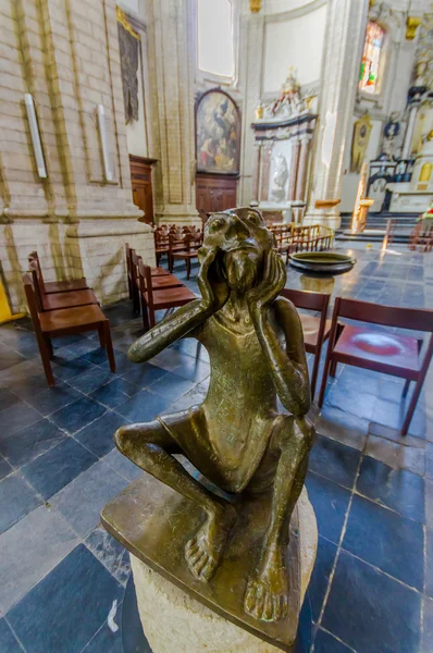 BRUSELAS, BÉLGICA - 11 AGOSTO, 2015: En el interior de la famosa Iglesia Nuestra Señora de la Asistencia, que muestra hermosa piedra blanca y arquitectura de hormigón, estatua artística de bronce con altar visible al final —  Fotos de Stock