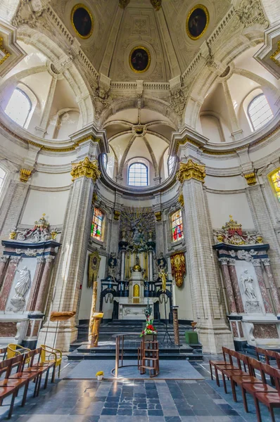 BRUSELAS, BÉLGICA - 11 AGOSTO, 2015: En el interior de la famosa Iglesia Nuestra Señora de la Asistencia, que muestra hermosa piedra blanca y arquitectura de hormigón, estatua artística de bronce con altar visible al final —  Fotos de Stock