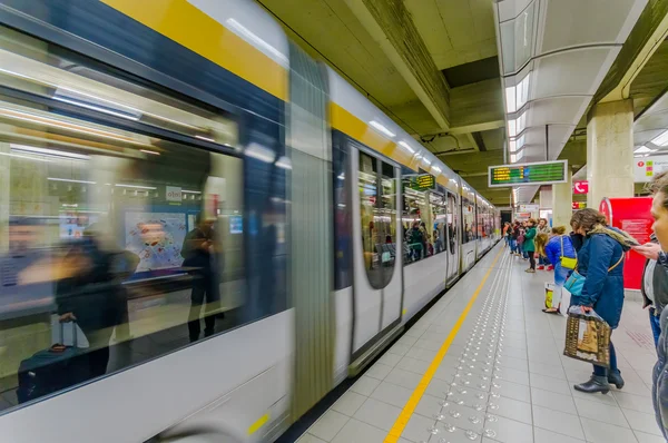 BRUSELAS, BÉLGICA - 11 AGOSTO, 2015: Dentro de la estación de Beurs en la plataforma de pasajeros que muestra el tren gris que llega con pocas personas esperando —  Fotos de Stock