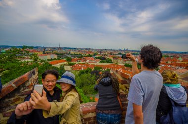 Prague, Czech Republic - 13 August, 2015: Tourists taking selfie shots at beautiful view point over city, great rooftop overview background