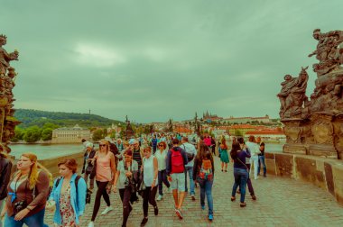 Prague, Czech Republic - 13 August, 2015: People crossing over famous Charles Bridge, statues visible alongside