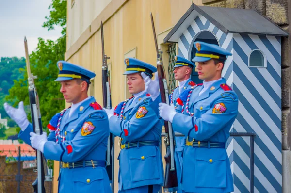 Prague, Tsjechië - 13 augustus, 2015: Palace dienstdoende dragen hun kenmerkende blauwe uniformen, witte gestreepte booth en wapen zichtbaar afschermingen — Stockfoto