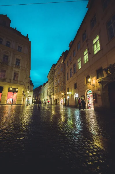 Praga, República Checa - 13 de agosto de 2015: Hermosas fachadas amarillas con carretera bridgestone pasando por una agradable noche lluviosa —  Fotos de Stock