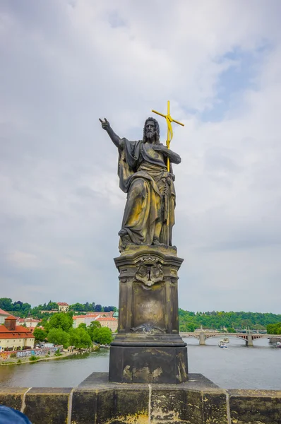 Praga, República Checa - 13 de agosto de 2015: El famoso Puente de Carlos y una de sus muchas estatuas famosas colocadas junto a él — Foto de Stock