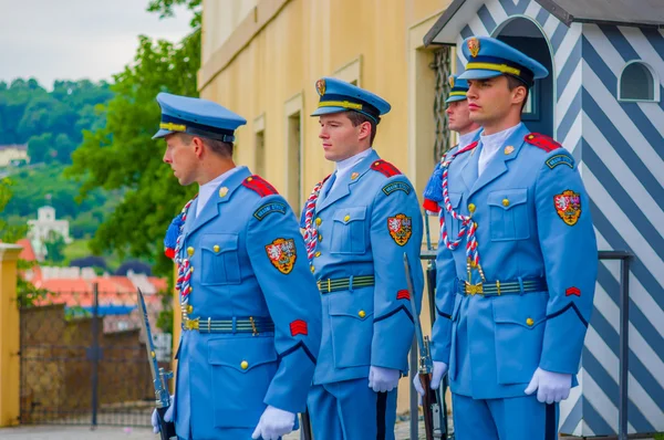 Πράγα, Δημοκρατία της Τσεχίας - 13 Αυγούστου, 2015: Παλάτι φύλακες ΕΦΗΜΕΡΕΥΟΝΤΑ φορώντας τους διακριτικό μπλε στολές, λευκό ριγέ περίπτερο και όπλο ορατή — Φωτογραφία Αρχείου