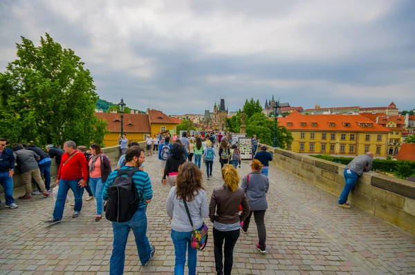 Prague, Czech Republic - 13 August, 2015: People crossing over charming city bridge on a nice cloudy day — Stockfoto