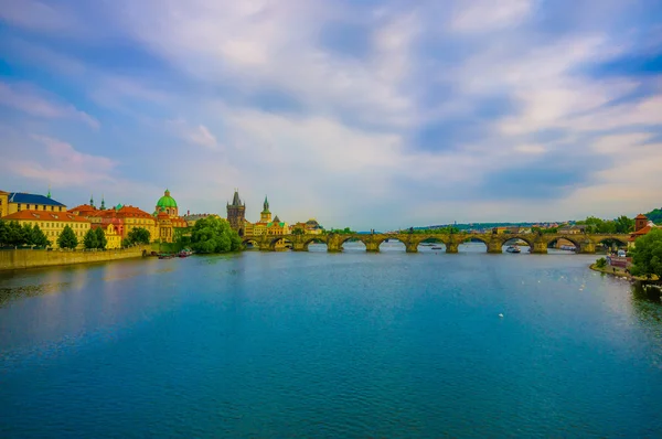 Prag, Tjeckien - 13 augusti, 2015: Vltava floden sett från staden med vackra Karlsbron i fjärran sträcker sig över vatten — Stockfoto
