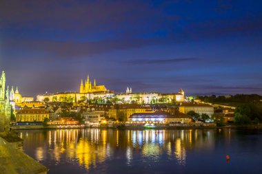 Prague, Czech Republic - 13 August, 2015: Waterfront view of Prague with beautiful lights shining reflective across water, evening sky