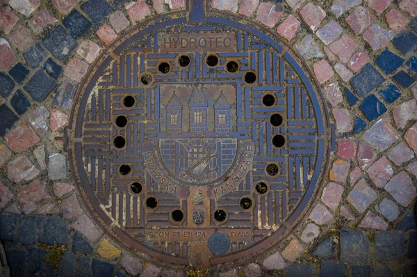 Prague, Czech Republic - 13 August, 2015: Old drain cover of metal found in the streets around city centre — Stockfoto