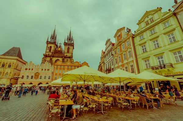 Prague, Czech Republic - 13 August, 2015: Crowded and lively street view from old town square, restaurants with tables plus people