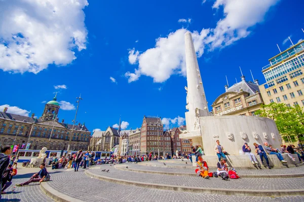 Amsterdam, Nizozemsko - 10 července 2015: Náměstí Dam na krásný slunečný den, vysoký památník a historických budov plaza a okolí — Stock fotografie