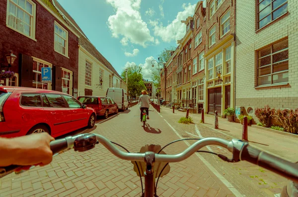 Amsterdam, Paesi Bassi - 10 luglio 2015: Il punto di vista dei motociclisti come andare in bicicletta per le strade della città in una bella giornata estiva — Foto Stock