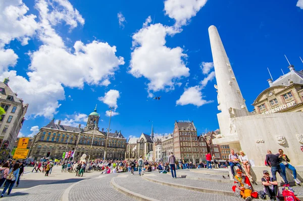 Άμστερνταμ, Ολλανδία - Ιούλιος 10, 2015: Πλατεία Dam σε μια όμορφη ηλιόλουστη μέρα, ψηλό μνημείο και ιστορικά κτήρια γύρω από την plaza — Φωτογραφία Αρχείου