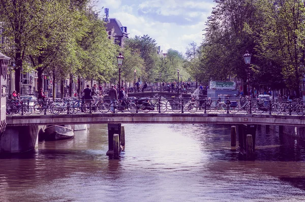 Amsterdam, Niederlande - 10. Juli 2015: zwei Brücken über Wasserkanal und Menschenmassen, Alltag in der Stadt — Stockfoto