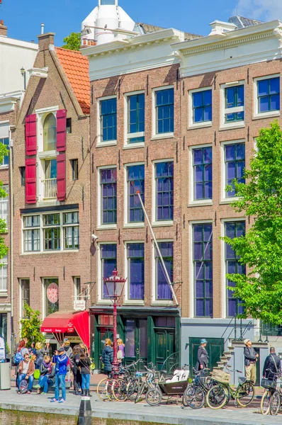 Amsterdam, Nederland - 10 juli 2015: Traditionele Nederlandse stad blokkeert met charmante rode bakstenen gebouwen — Stockfoto