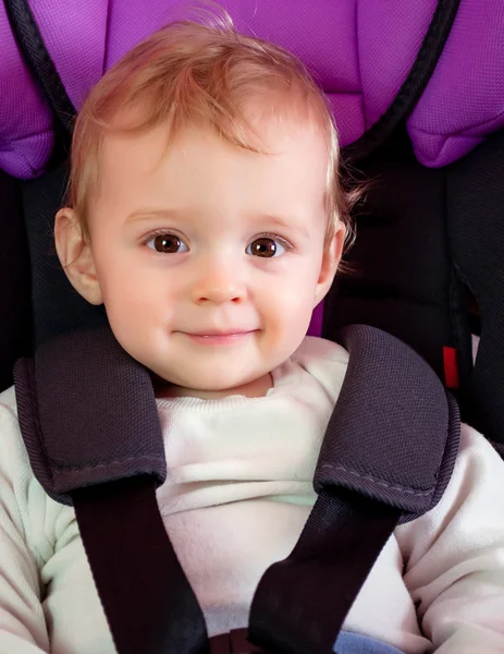 Bebek gülümsüyor ve koltukta oturur