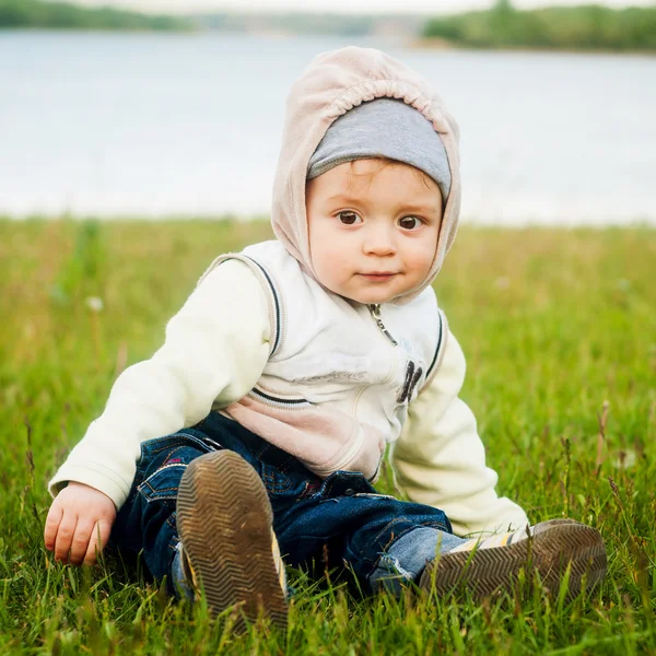 El bebé jugando en la hierba en el río — Foto de Stock