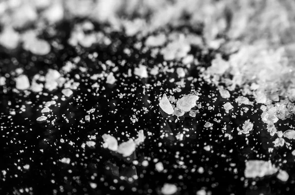 Kryształy soli, rozrzucone na czarne tło zbliżenie — Zdjęcie stockowe