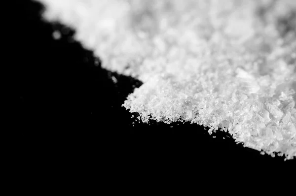Salt crystals scattered on a black background closeup — Stock Photo, Image