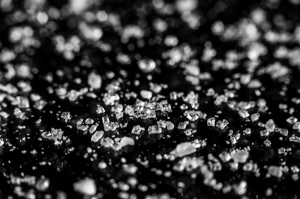 Scattered crystals of sugar on black background — Stock Photo, Image