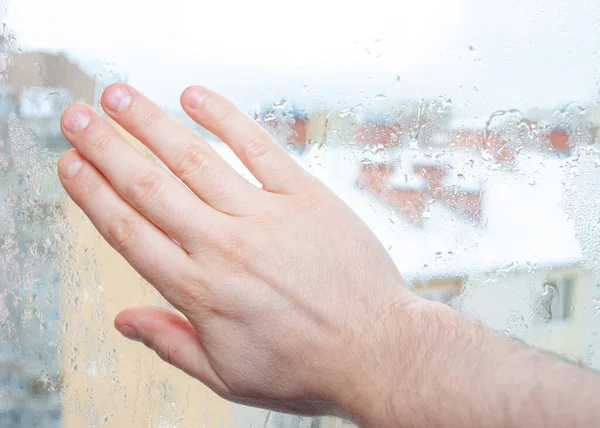 hand wipes the fogged window .