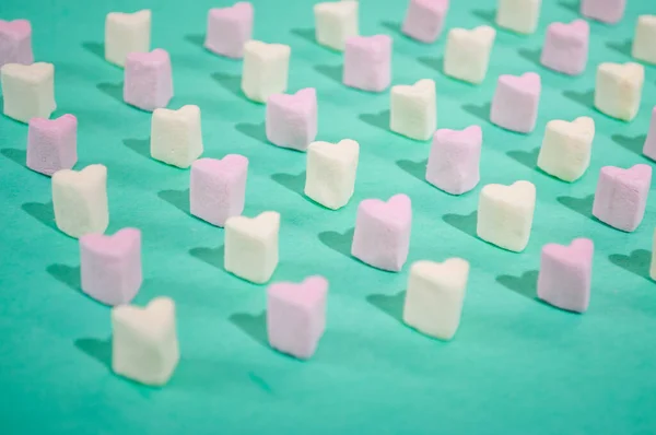 Candy of different colors on a turquoise background, a heart texture on Valentines Day — Fotografia de Stock