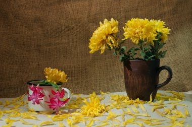 Natürmort kil kupalar ve çiçeklerle masa örtüsü üzerinde