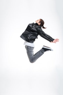 Attractive young man in black leather jacket jumping high