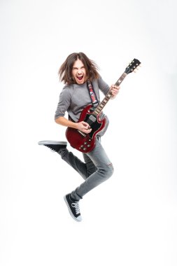 Happy man with long hair jumping and playing electric guitar