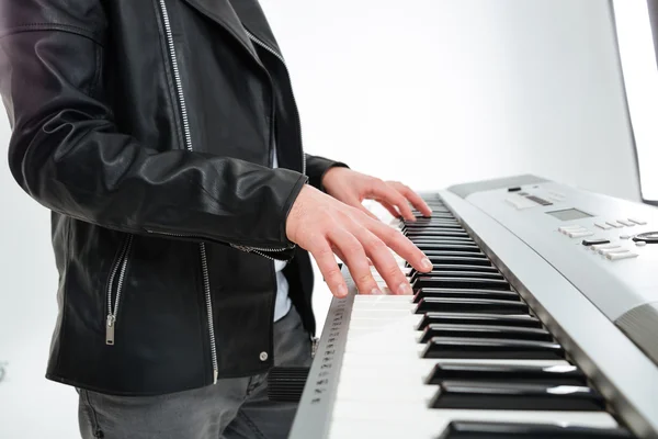 Hands of young man standing and playing on synthesizer — ストック写真