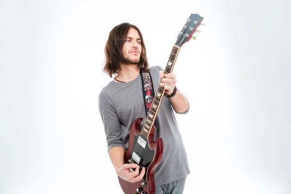 Attractive charismatic male guitarist standing and playing electric guitar — Stock Photo, Image