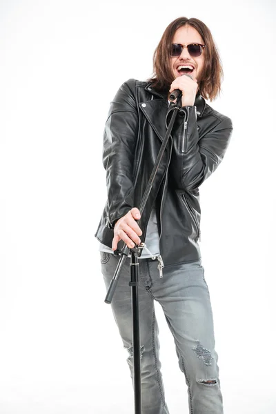 Carismático cantor masculino em óculos de sol de pé e cantando em micofone — Fotografia de Stock