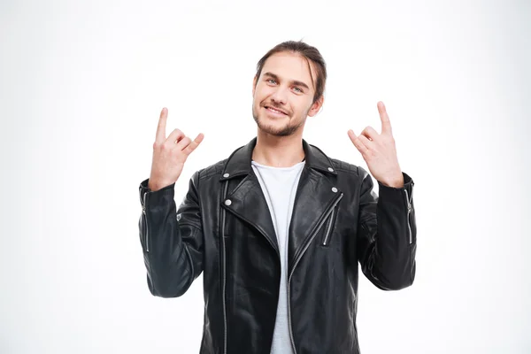 Smiling handsome man in black leather jacket doing rock gesture — 스톡 사진