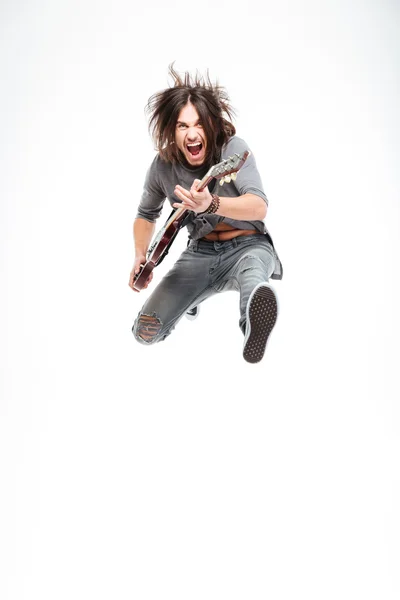 Возбужденный веселый гитарист с электрогитарой, кричащий и прыгающий — стоковое фото