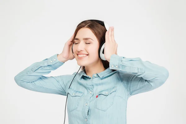 Sorrindo bonito linda mulher usando fones de ouvido e ouvir música — Fotografia de Stock