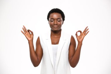 Peaceful attractive african american young woman meditating and keeping calm  clipart