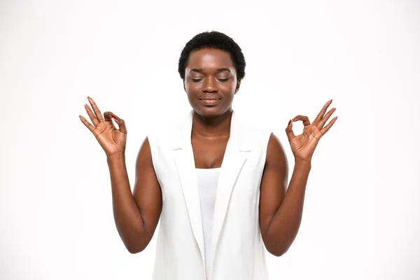 Peaceful attractive african american young woman meditating and keeping calm — Zdjęcie stockowe