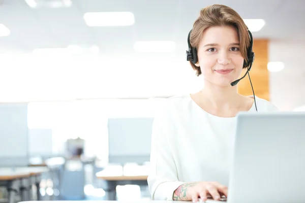 Sorrindo mulher de apoio ao cliente operador de chamada no escritório — Fotografia de Stock